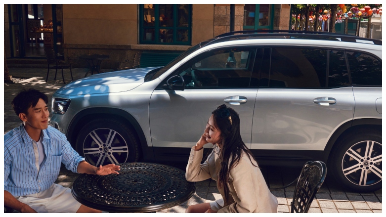 Vista lateral de SUV hibrida Mercedes-Benz GLB 200 gris aparcada en la vía.