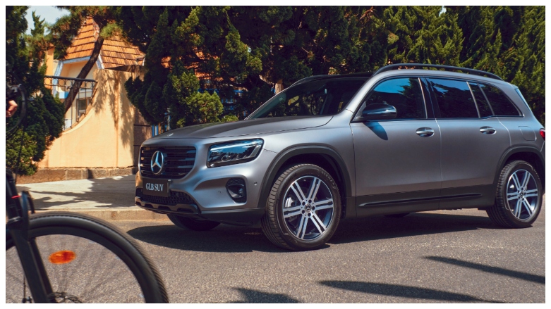 Vista frontal y lateral de SUV hibrida Mercedes-Benz GLB 200 gris aparcada en la vía.