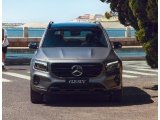 <p>SUV hibrida Mercedes-Benz GLB 200 gris aparcada en la vía con el mar al fondo.</p>
