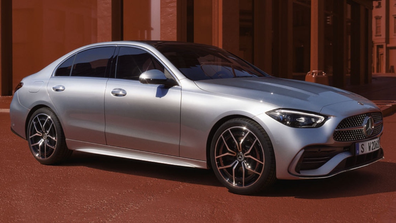 Mercedes Benz Clase C Sedan color gris con fondo de ciudad roja