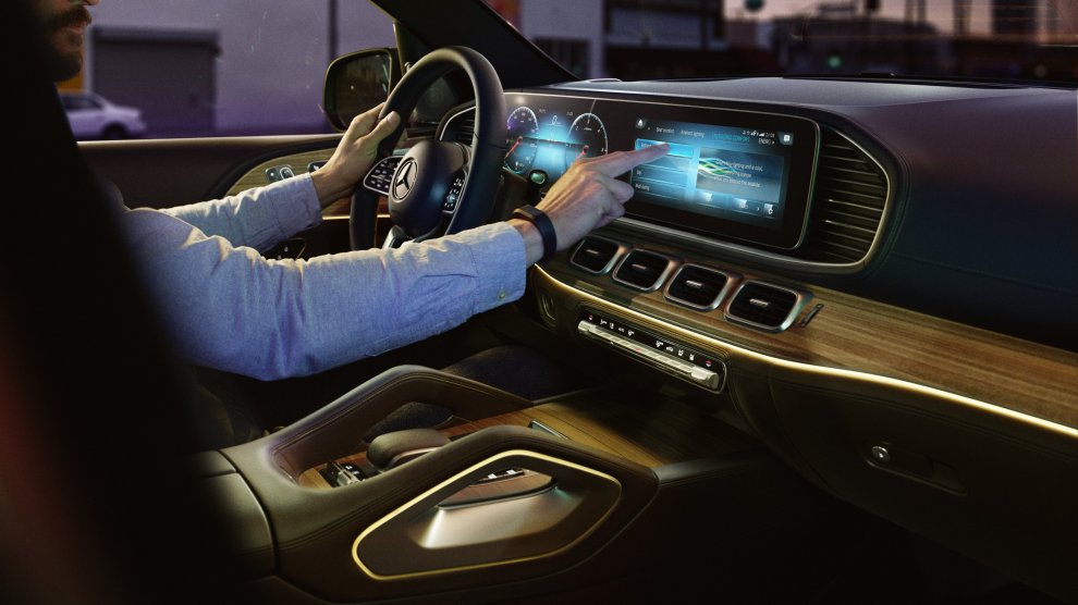 <p>Persona conduciendo Mercedes Benz GLE con vista hacia el tablero con pantalla tactil</p>