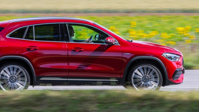 <p>Mercedes Benz GLC color rojo conduciendo sobre autopista con fondo natural</p>