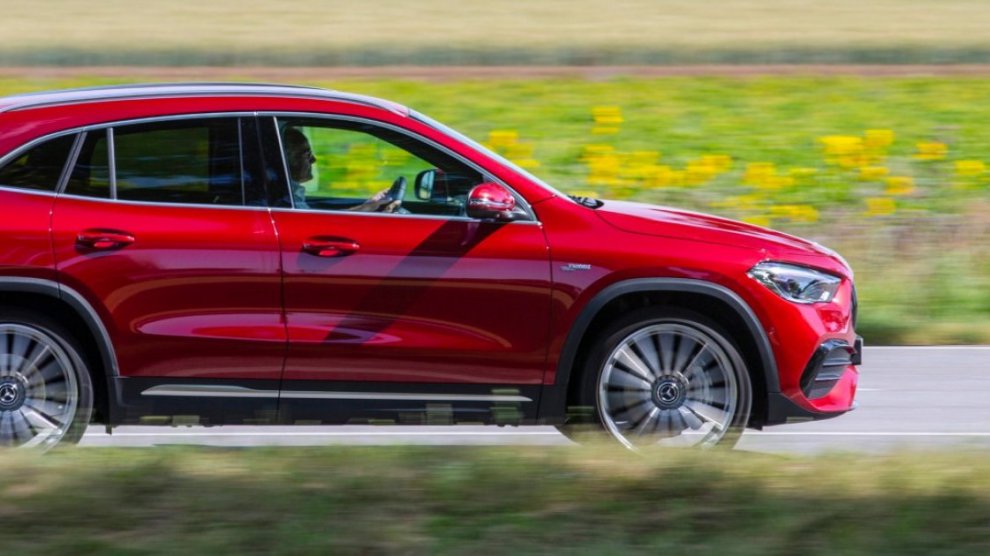 <p>Mercedes Benz GLC color rojo conduciendo sobre autopista con fondo natural</p>