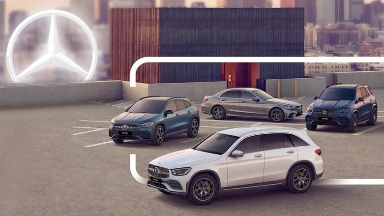 <p>Vehículos Mercedes-Benz estacionados en estacionamiento con ciudad de fondo.</p>