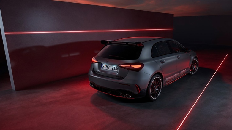 Vista trasera lateral de auto deportivo Mercedes-AMG Clase A color gris oscuro con luces de neón. 