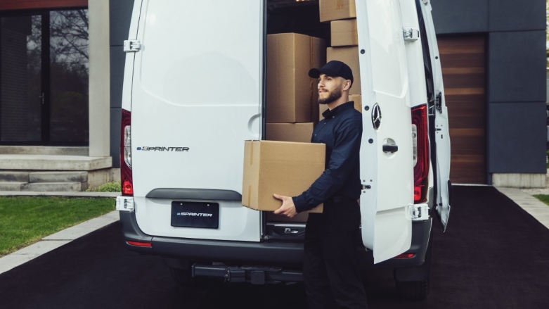 Personas bajando cajas de van eléctrica eSprinter por la puerta trasera.