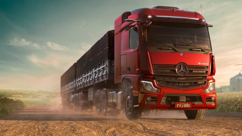 Camion de carga New Actros 2548 color rojo siendo conducido por terreno rocoso.